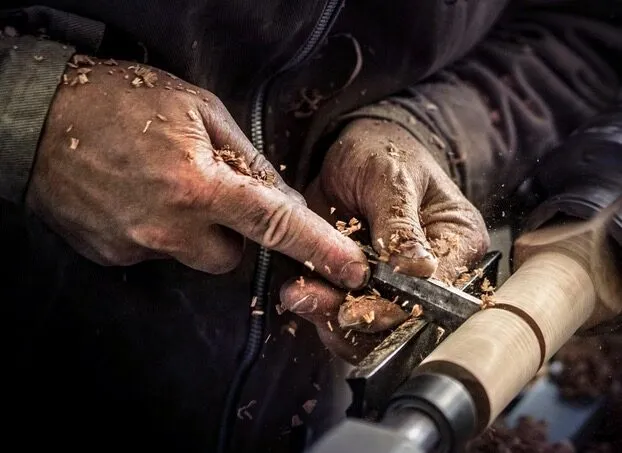 Mani che lavorano il legno al banco nei laboratori Tosetto
